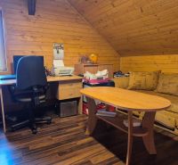 An interior with a work corner, wooden paneling, and a floor with a wood decor.