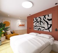 Bright bedroom with an orange wall, bed, and plant in a 3-room apartment.