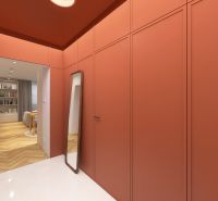 A hallway in a 3-room apartment with orange walls and a wooden decor floor.