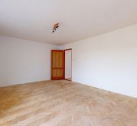 A spacious room with a wooden decor floor in a 3-room apartment.