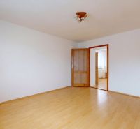 A spacious room with a wooden decor floor in a 3-room apartment.