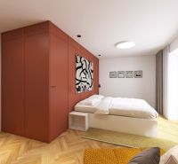 A bedroom with wood-patterned flooring, a large window, and an orange cabinet in a three-room apartment.