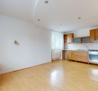 A kitchen with wooden floor decor in a spacious 3-room apartment with light from the window.