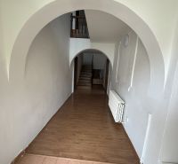 Interior of a family house with arches and wood-patterned flooring.