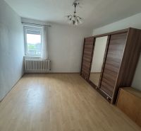 A room with a wooden floor decor, a wardrobe, and a window in a family house.