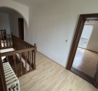 A staircase with a wooden railing and a floor with a wooden decor in a family house.