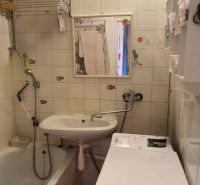 Bathroom with a bathtub, sink, and washing machine in a 3-room apartment.