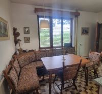 Dining area in a family house with windows and checkered floor.