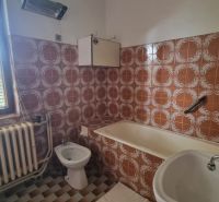 Bathroom with tiles and a bathtub in a family house.