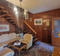 Interior of a family house with wooden wall paneling and comfortable leather seating.