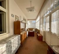 Interior of a sunny winter garden with furniture and decorative curtains in the plot - living.