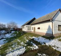 A family house in Vrakúňa surrounded by a garden with a lawn and remnants of snow.