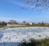 Snow-covered residential plots in Vrakúňa with a view of houses on an unknown street.