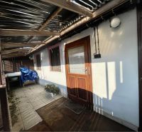 Covered courtyard with wooden doors and plants in Vrakúňa, suitable for residential plots.
