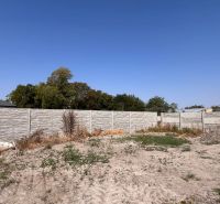 A family house in Povoda with a concrete fence, garden, and greenery under a blue sky.