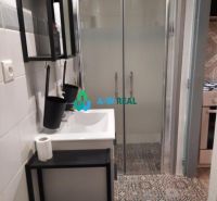 Bathroom with a sink, shower stall, and patterned tiles in a family house.