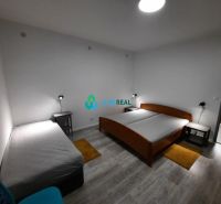 A bedroom in a family house with beds and a wooden decor floor.