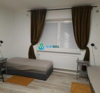 A room in a family house with beds, nightstands, and a floor with a wooden decor.