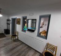 Interior of a family house with a wooden decor floor, white walls, and furniture.