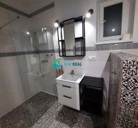 A bathroom in a family house with decorative tiles and a shower corner.