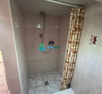 Shower corner with tiles and curtain in a family house.