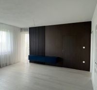 Living room with a dark wall and wood-decorated floor in a 3-room apartment.