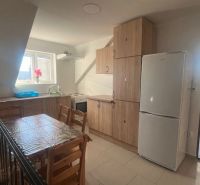 A kitchen in a building with wooden decor furniture and a dining table.