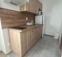 A kitchen with wooden decor, white appliances, a sink, and tiles on the wall.