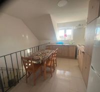 A kitchen in a building with wooden decor and a dining table.