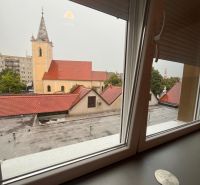 A view from the window of a one-room apartment to the church in Dunajská Streda on a cloudy day.