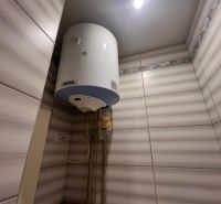 Water heating in the bathroom: boiler and tiles in a studio apartment.
