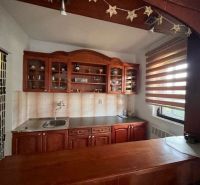 A kitchen in a family house with wooden cabinets and decorative elements.