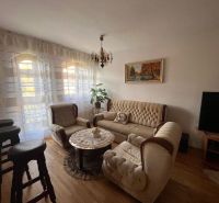 Living room in a family house with a wooden decor floor, a couch, and a television.