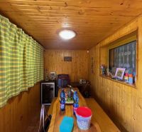 Interior of a family house with wooden paneling, a table, and decorative items.