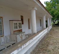 An older family house in Ňárad with a veranda and vintage furniture in front of the house.
