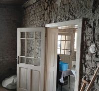 Old wooden doors and bare walls in the interior of a family house.