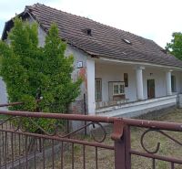 A family house in Ňárad with a classic tiled roof and a landscaped garden behind the gate.