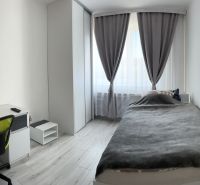 A minimalist bedroom in a family house with a desk and a wooden decor floor.
