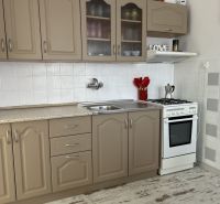 A kitchen in a family house with beige cabinets, a white stove, and decorative accessories.