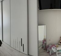 Bedroom in a family house with a bed, wardrobe, toys, and a decorative mirror.