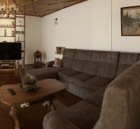 Living room in a family house with a sofa set and a television, floor with wooden decor.