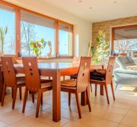 Dining room in a family house with a spacious table, wooden chairs, and plant decorations.