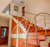 A staircase in a family house with a wooden decor floor and metal railing.