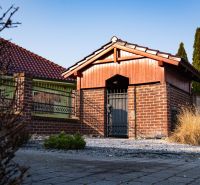 A family house in Dolný Bar with a brick fence and a metal gate.