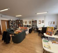 A library with comfortable seating and a wooden decor floor in a 3-room apartment.