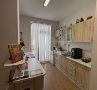A kitchen with a wooden decor floor and a kitchen unit in a 3-room apartment.