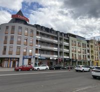 A building with shops on Galantská cesta in Dunajská Streda, cars parked in front of it.