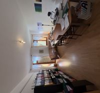A study with a wooden decor floor in a 3-room apartment, full of documents and furniture.