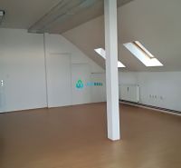 Attic office with white walls and a wooden decor floor.