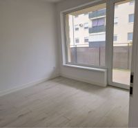 A room with a large window and a wooden decor floor in a 3-room apartment.